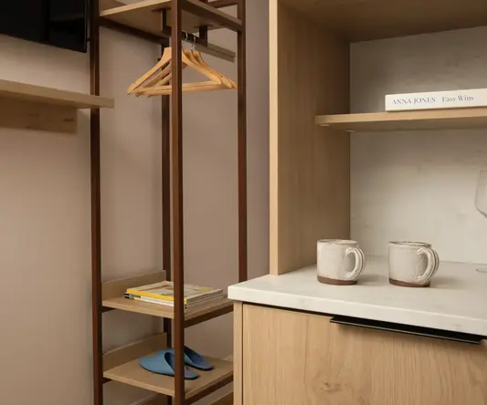 a shelf with a swinger and coffee cups in a room