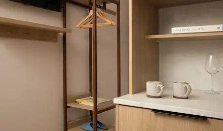 a shelf with a swinger and coffee cups in a room