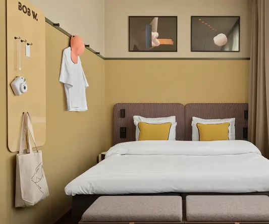 a bed with pillows and a bench in a room