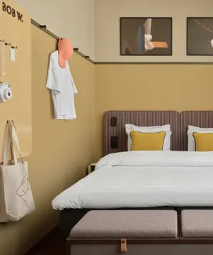 a bed with pillows and a bench in a room