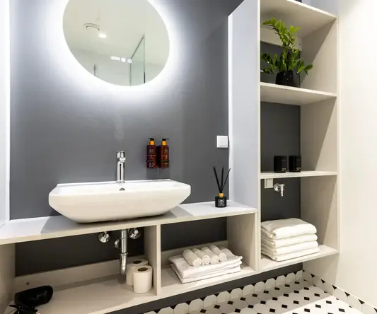 a bathroom with a round mirror and a sink