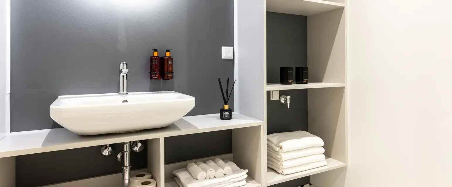 a bathroom with a round mirror and a sink