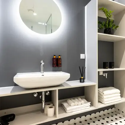 a bathroom with a round mirror and a sink