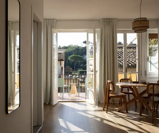 a room with a table and chairs and a door open