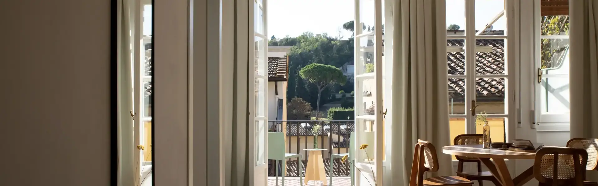 a room with a table and chairs and a door open