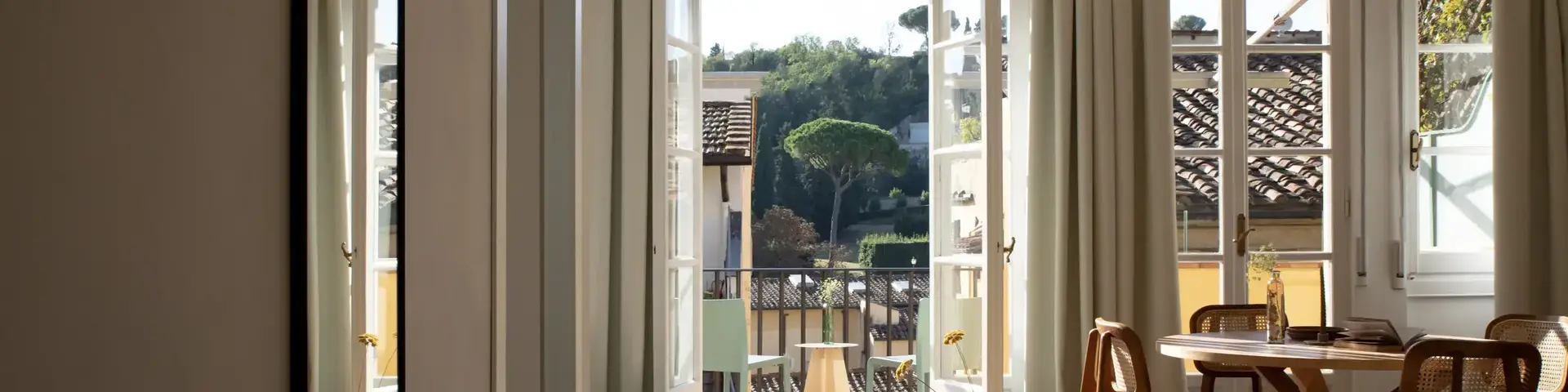 a room with a table and chairs and a door open