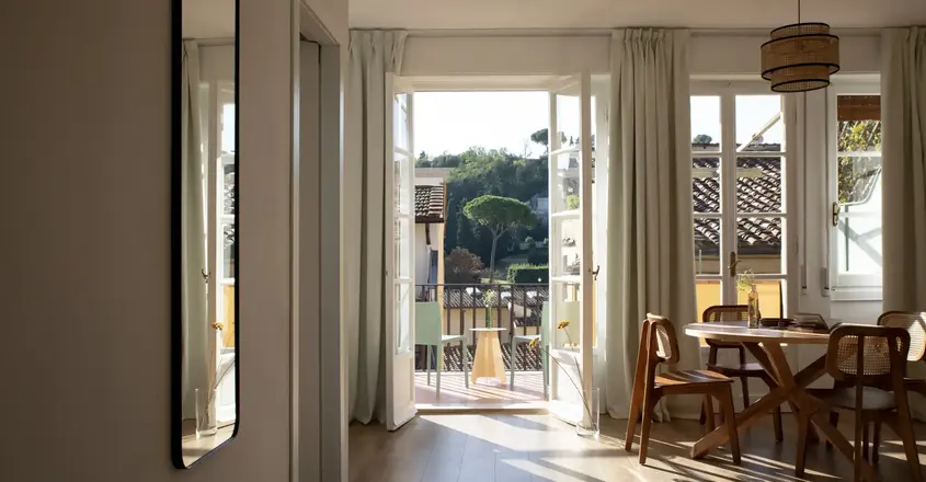 a room with a table and chairs and a door open