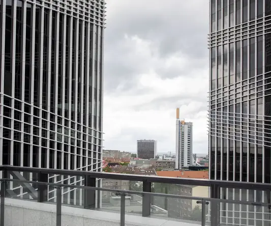 a two tall buildings with a glass railing