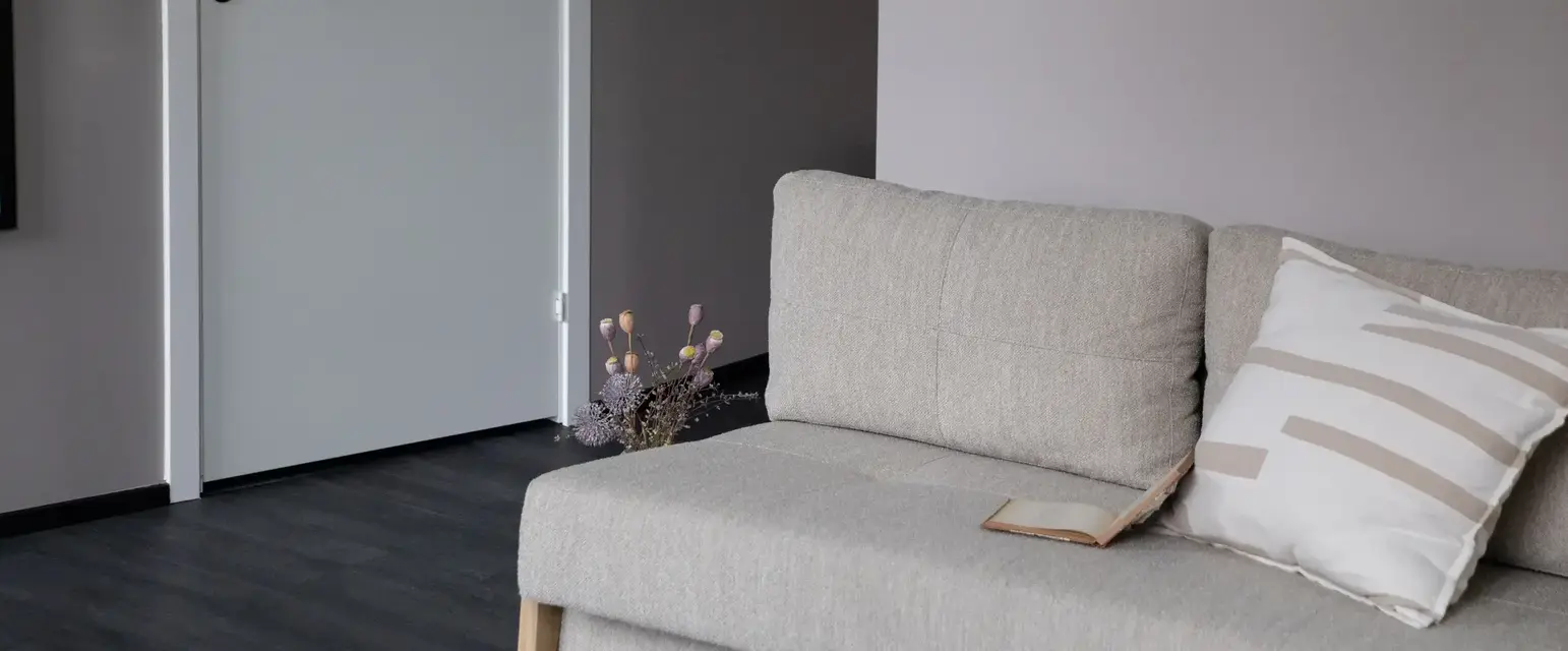 a couch with pillows and a book on it