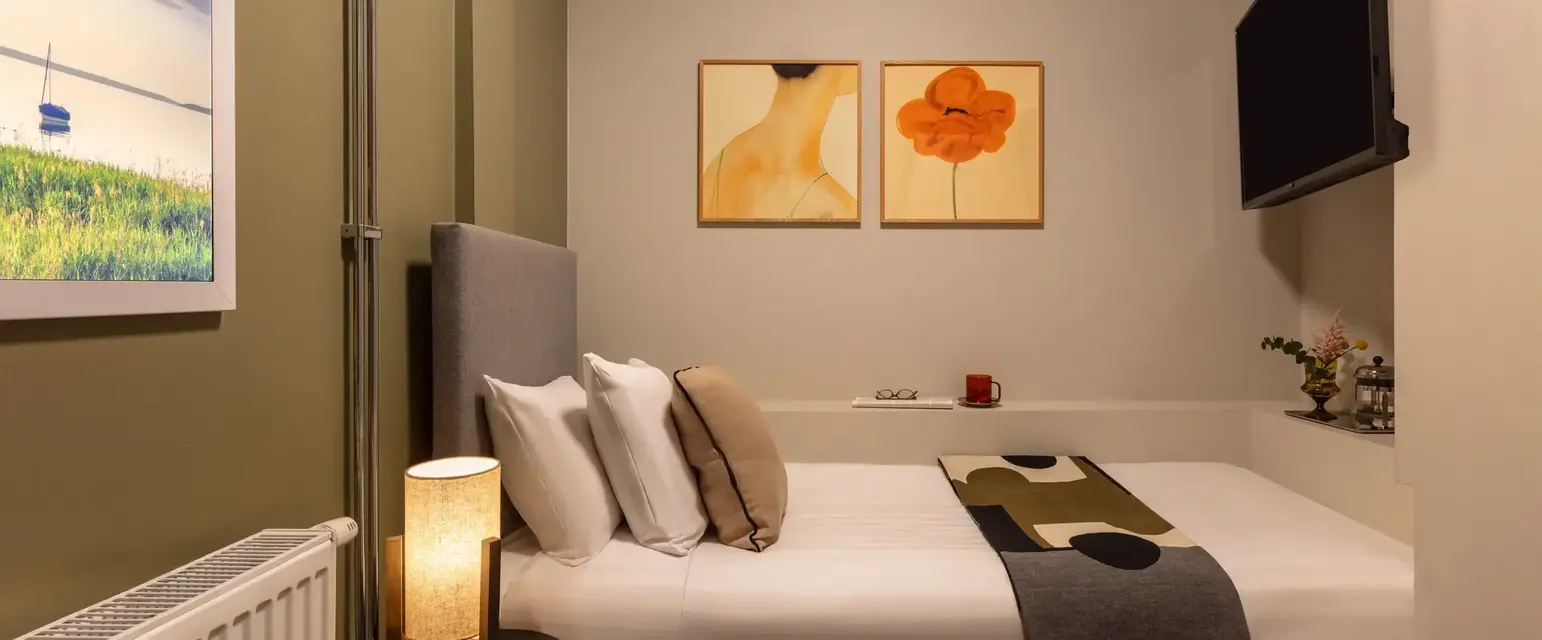 a bed with pillows and a lamp in a room