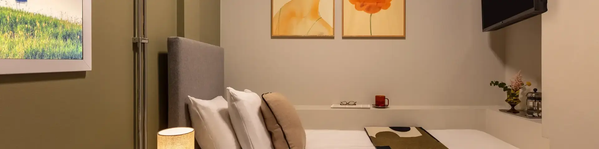 a bed with pillows and a lamp in a room