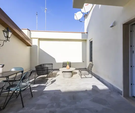 a patio with chairs and a table