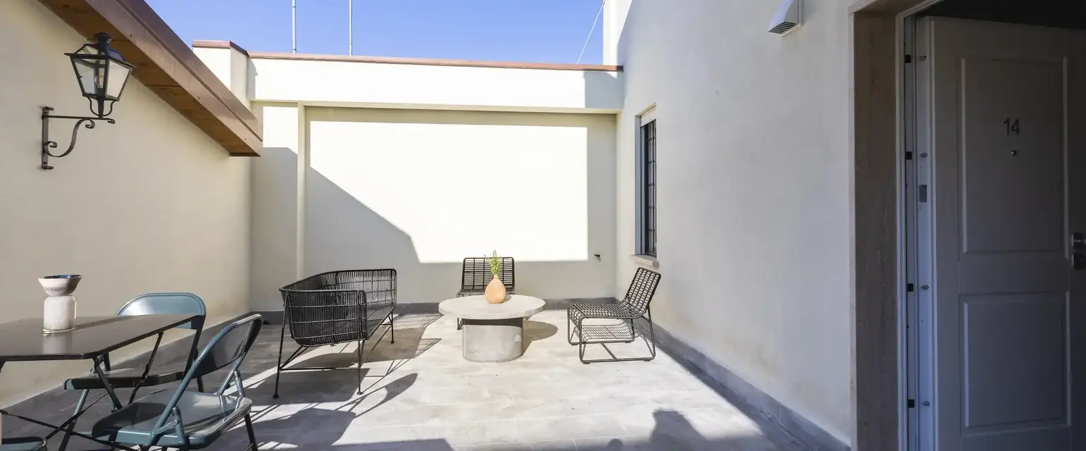 a patio with chairs and a table
