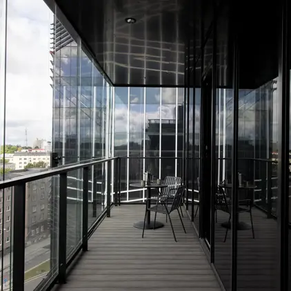 a balcony with chairs and a glass wall