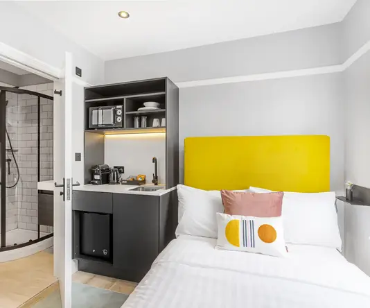 a bed with a yellow headboard in a room