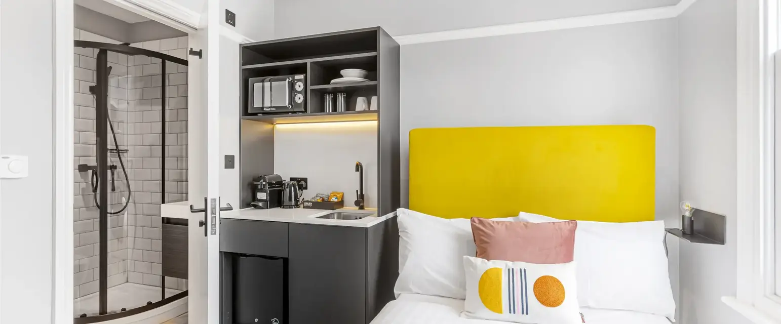 a bed with a yellow headboard in a room
