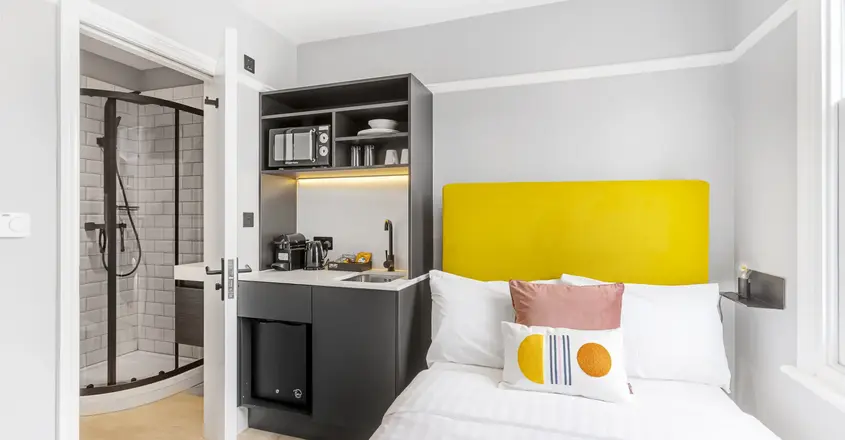 a bed with a yellow headboard in a room