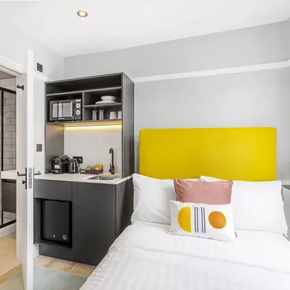 a bed with a yellow headboard in a room