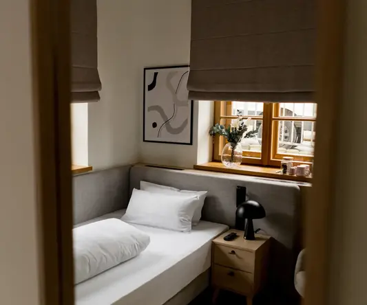 a bed with pillows and a lamp in a room