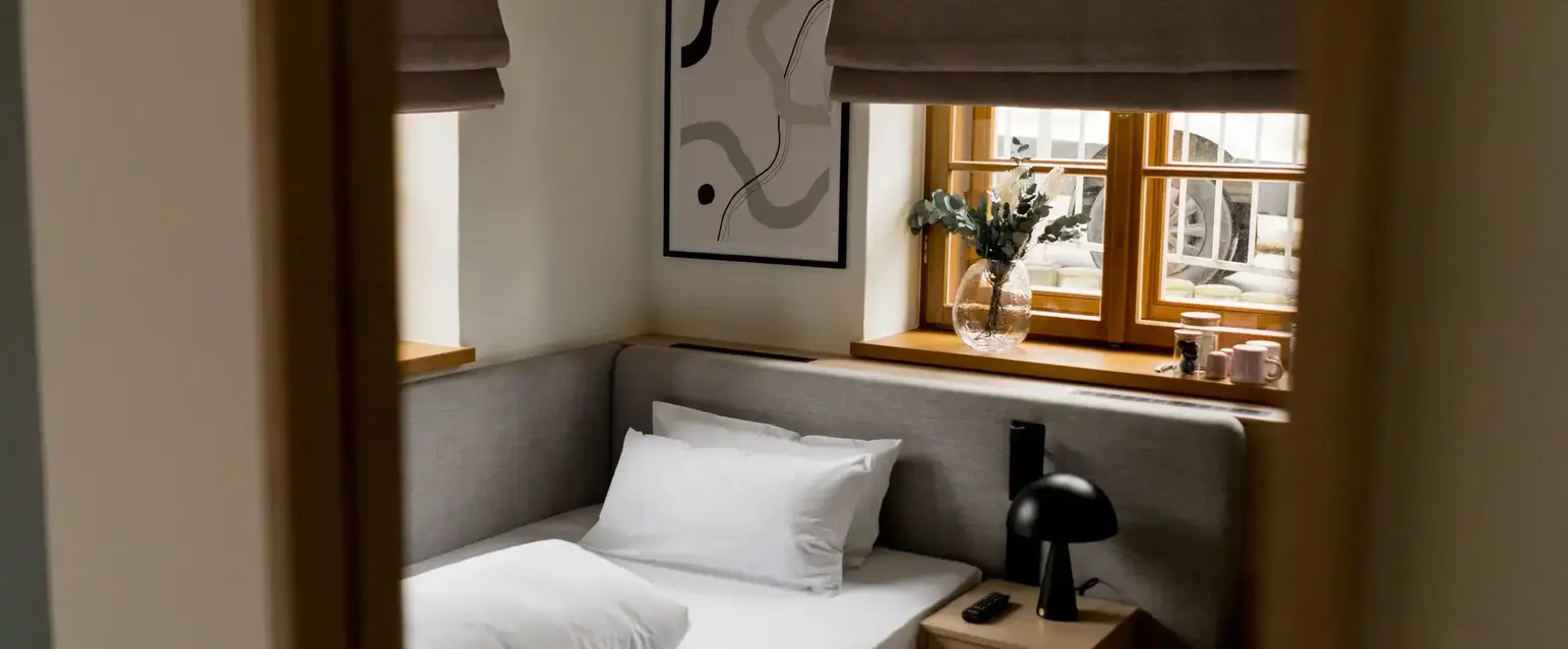 a bed with pillows and a lamp in a room