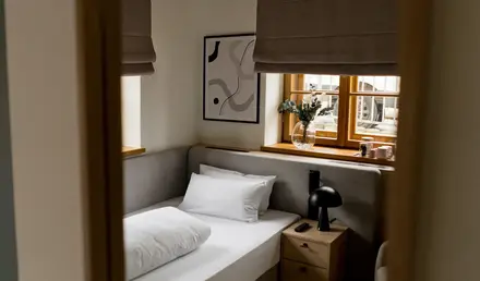 a bed with pillows and a lamp in a room