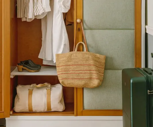 a closet with clothes and a bag