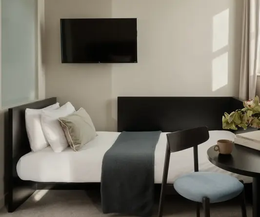 a bed with a tv on the wall