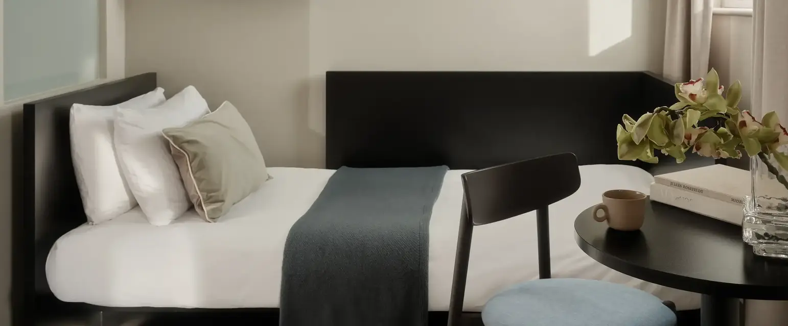 a bed with a tv on the wall