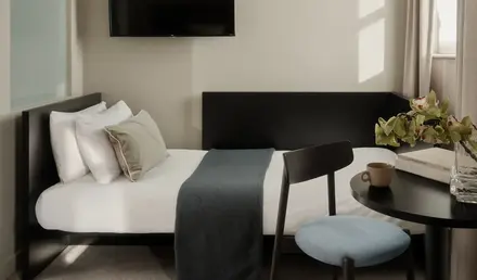 a bed with a tv on the wall