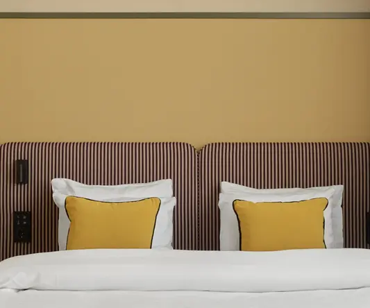 a bed with pillows and a striped headboard