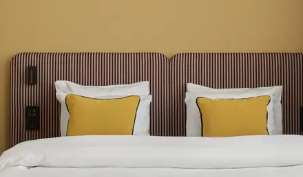 a bed with pillows and a striped headboard