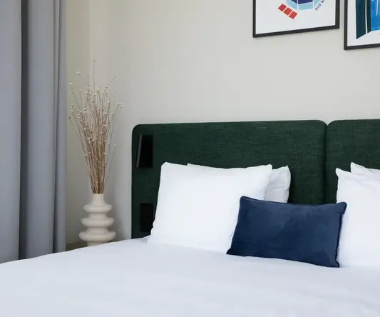 a bed with white sheets and pillows