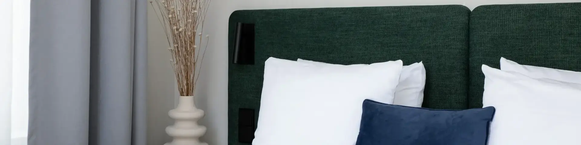 a bed with white sheets and pillows