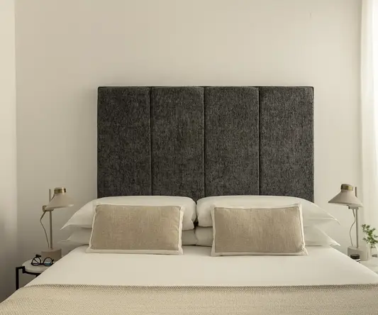 a bed with a headboard and lamps
