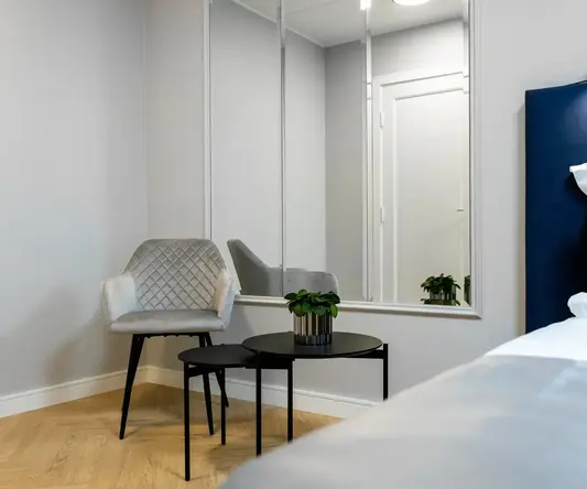 a room with a mirror and a chair