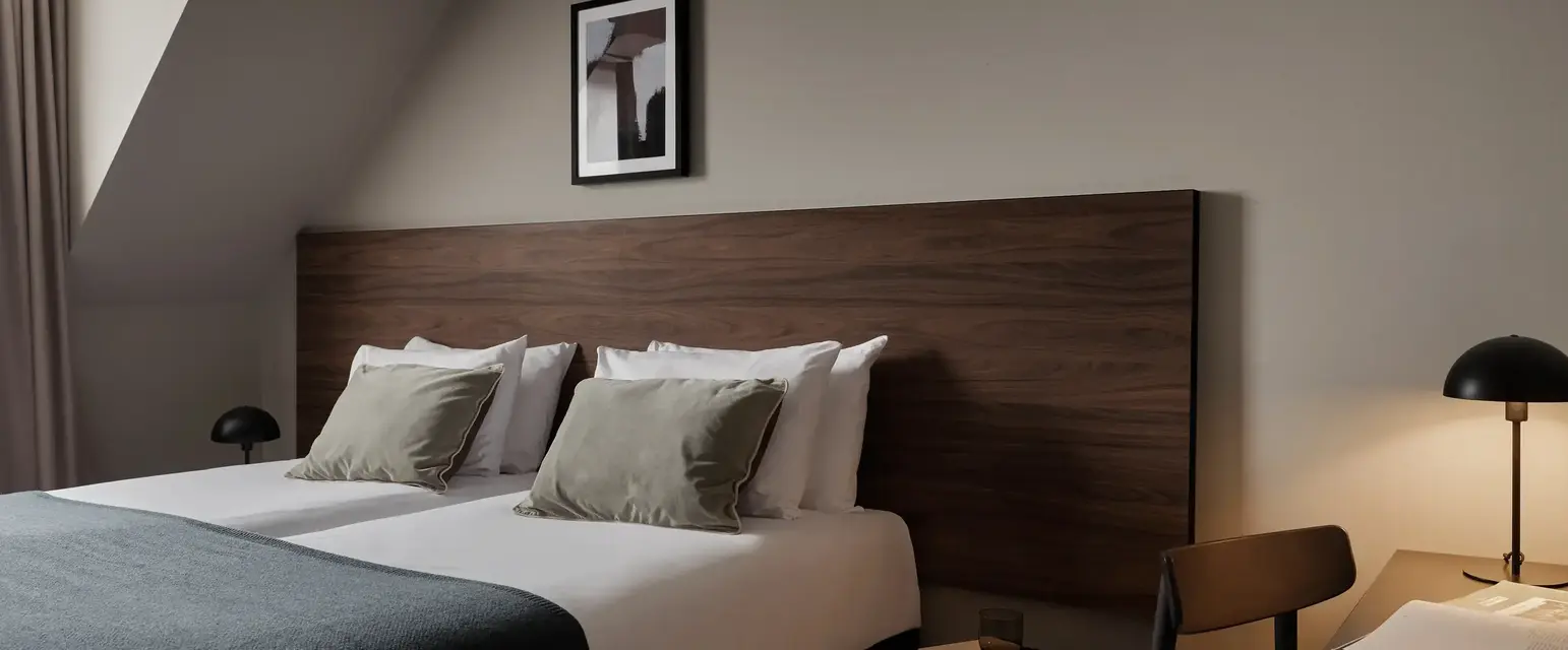 a bed with a wood headboard and a lamp