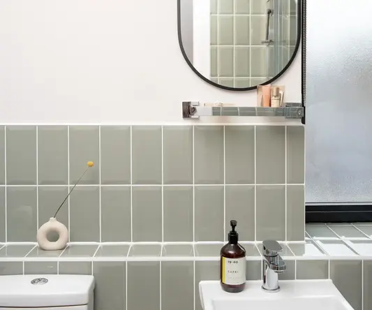 a bathroom with a round mirror and a sink