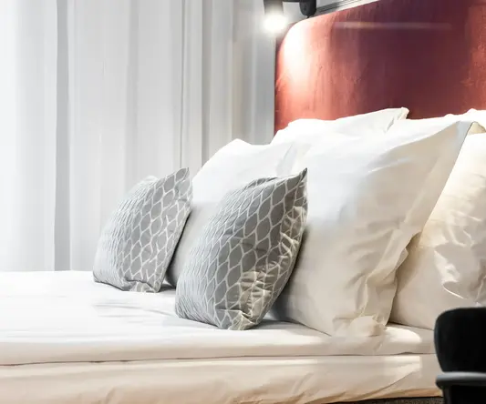 a bed with pillows and a red headboard