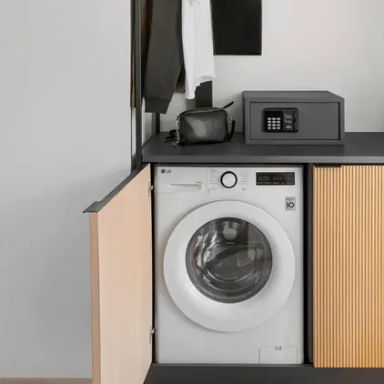 a laundry room with a washing machine and a black box