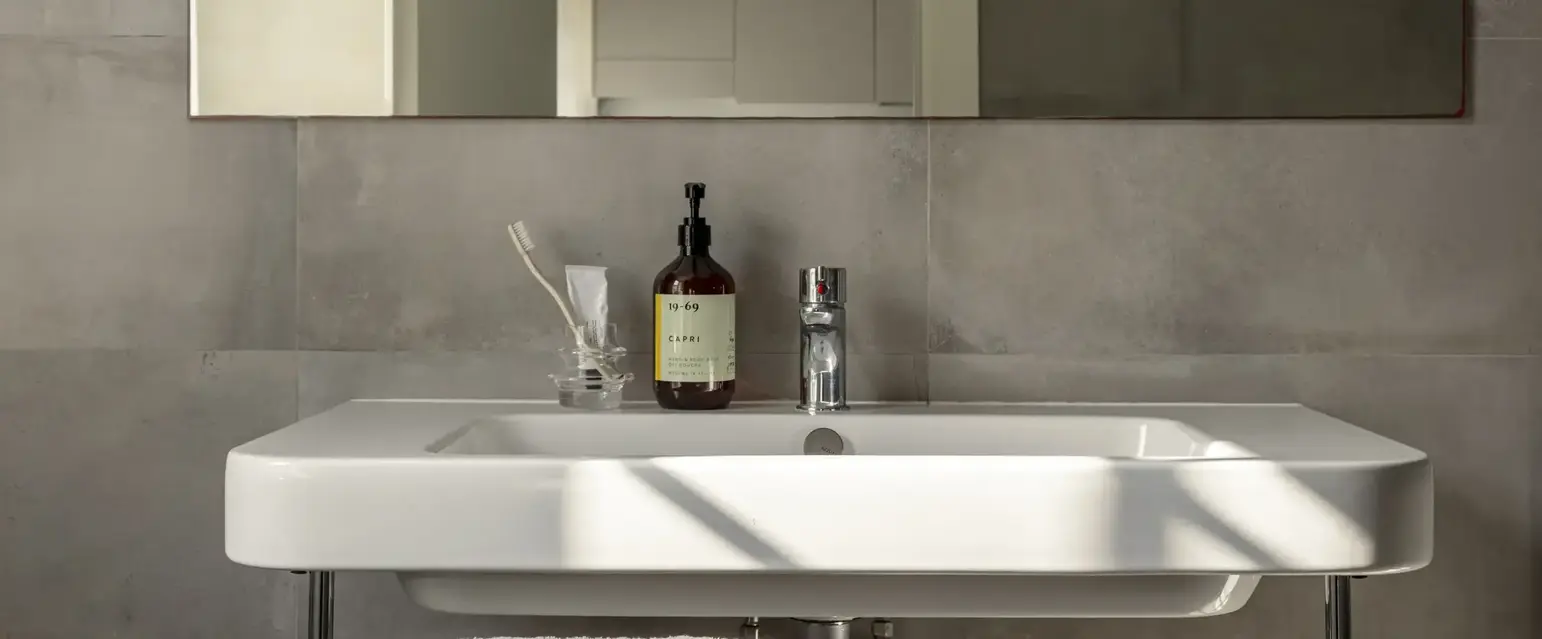 a bathroom sink with a bottle of soap and a towel