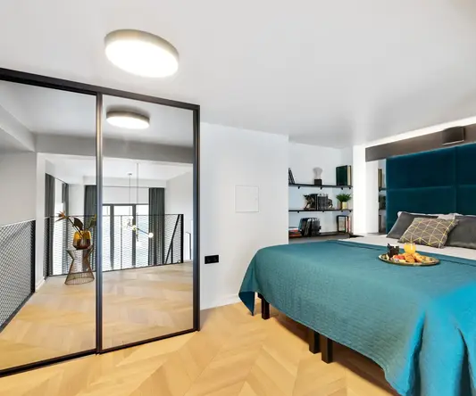 a bedroom with a blue bed and a glass door