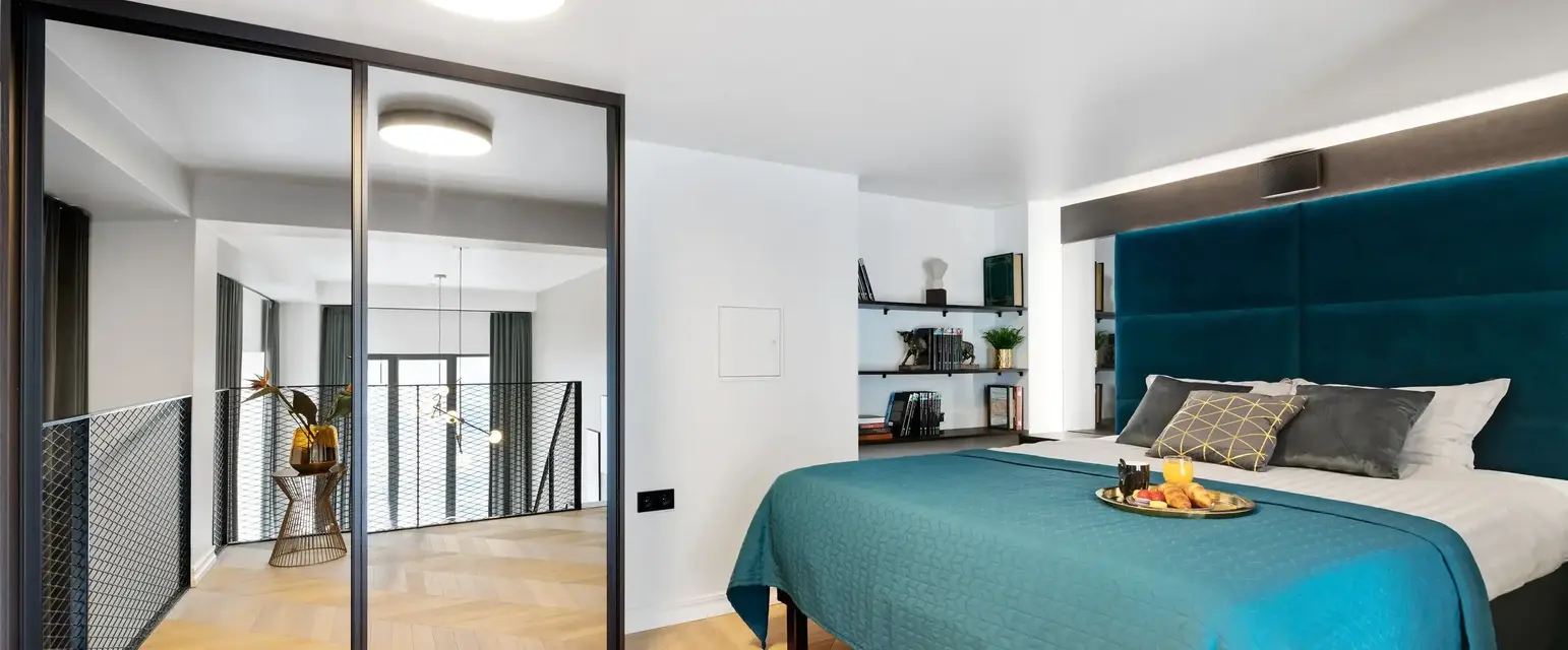 a bedroom with a blue bed and a glass door