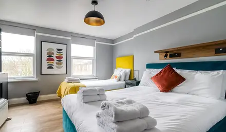 a room with two beds and a bed with towels