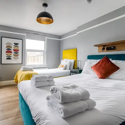 a room with two beds and a bed with towels