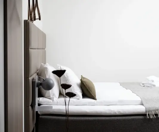 a bed with pillows and a plant