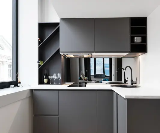 a kitchen with grey cabinets and a black sink