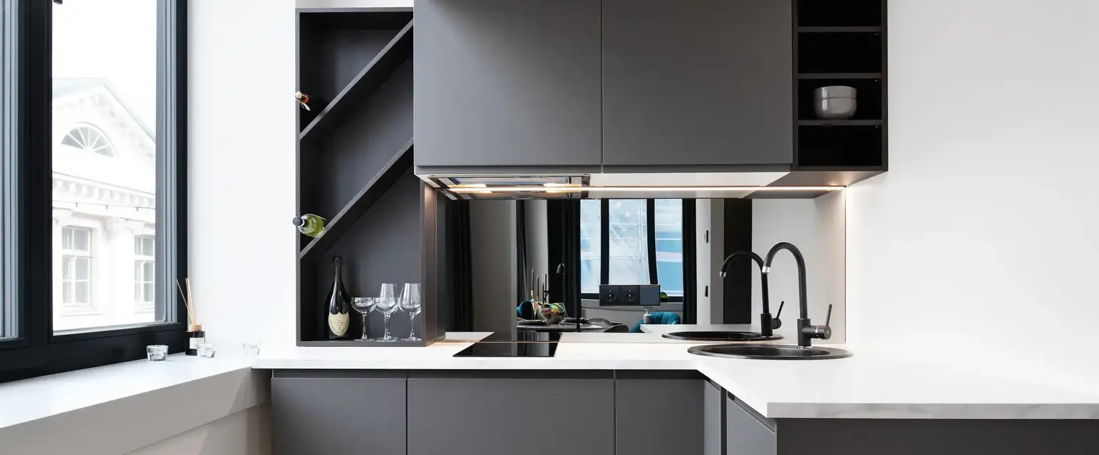 a kitchen with grey cabinets and a black sink