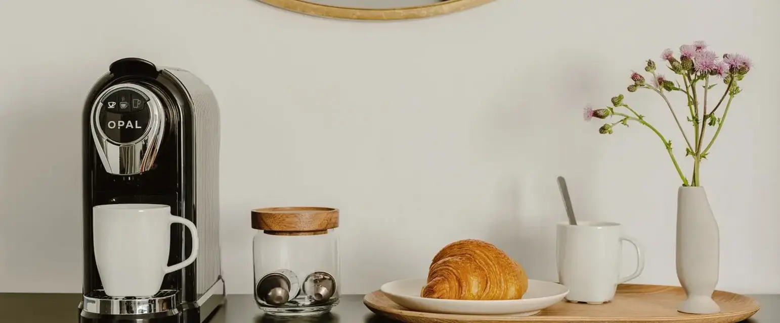 a coffee machine and croissant on a table