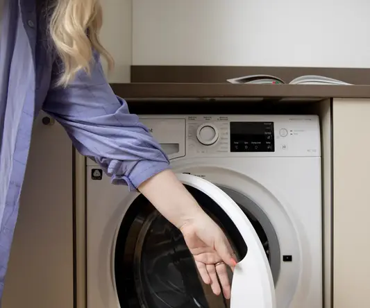 a woman opening a washing machine