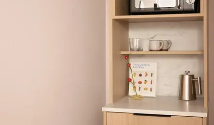 a shelf with a microwave and mugs on it